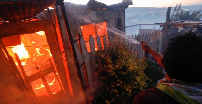 Vista de una de las más de un centenar de viviendas han quedado consumidas por las llamas en un incendio forestal que alcanzó ayer martes un sector poblado de la ciudad costera de Valparaíso