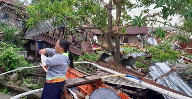 Una mujer a los pies de su hogar devastado por el tifón 'Úsula', en Biliran (Filipinas). - VIA REUTERS / SOCIAL MEDIA