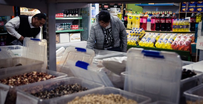 Una mujer mira la comida en una tienda en Usera. SANDRA BLANCO