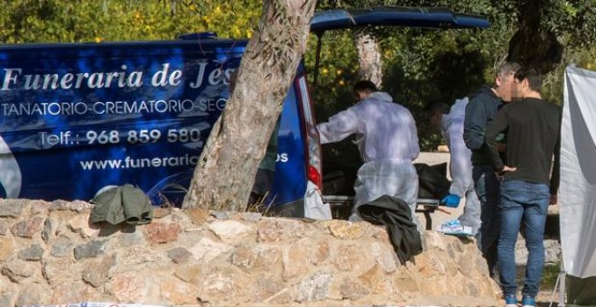 La Guardia Civil introduce el cadáver de la fallecida en un furgón de una funeraria. EFE