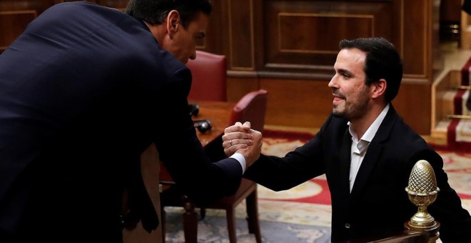 El coordinador de Izquierda Unida, Alberto Garzón (d), saluda al candidato a la Presidencia del Gobierno, Pedro Sánchez (i), tras su intervención ante el pleno del Congreso de los Diputados en la primera jornada de la sesión de investidura de Pedro Sánche