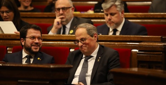 El vicepresident i el president de la Generalitat, Pere Aragonès i Quim Torra, somriuen en els seus escons durant un ple extraordinari convocat després de la decisió de la Junta Electoral Central (JEC) d'inhabilitar Torra. Pau Venteo / Europa Press