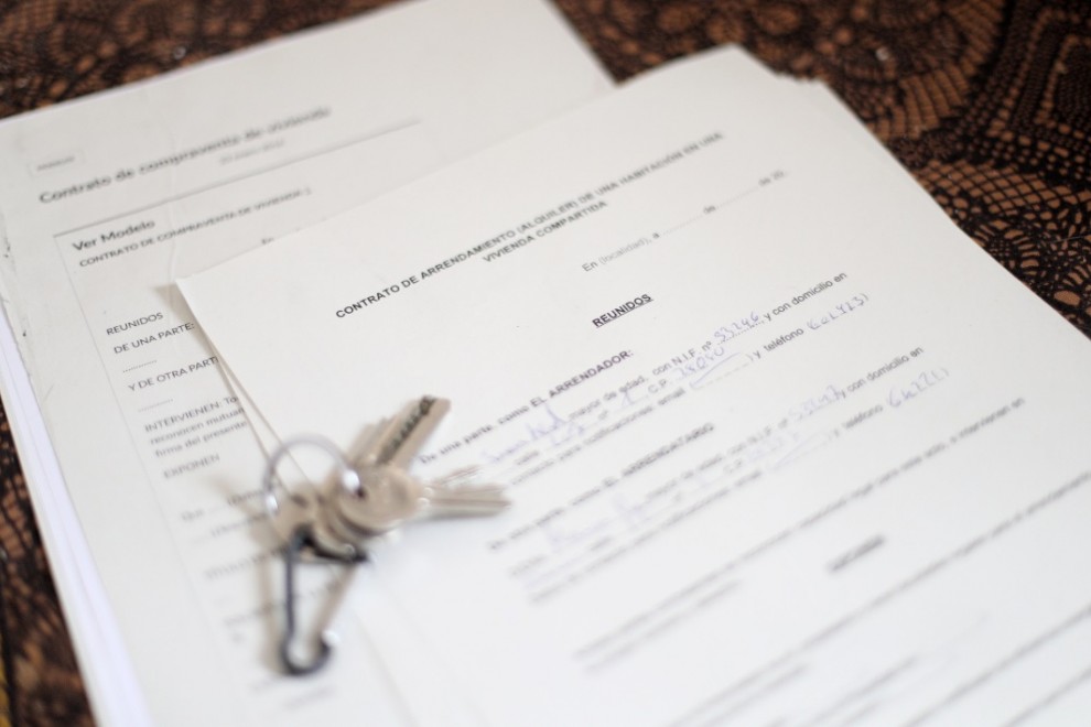 Unas llaves sobre un contrato de compraventa de vivienda y un contrato de arrendamiento (alquiler) de una habitación en una vivienda compartida. / ARCHIVO EUROPA PRESS