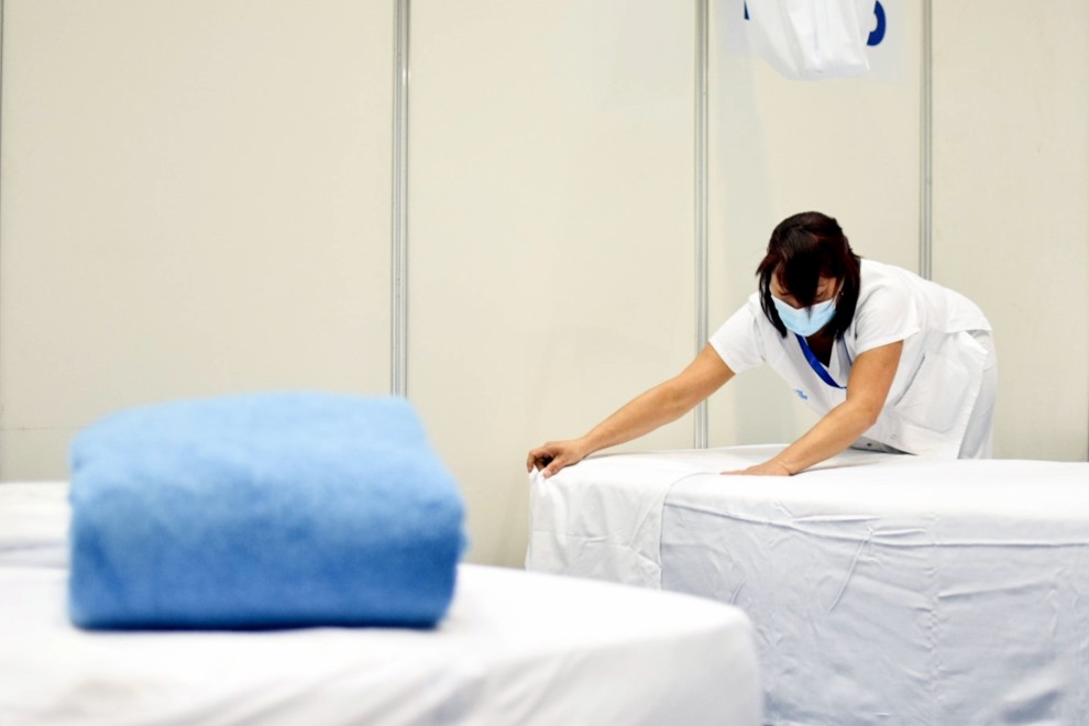 Una sanitària fent un dels llits del pavelló Olímpic de la Vall d'Hebron de Barcelona /ACN i Ajuntament de Barcelona