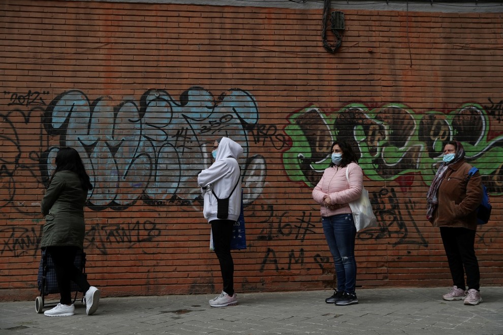 Personas  haciendo cola para recibir alimentos donados por voluntarios de la asociación Vecinos Parque Aluche, en Madrid, durante el estado de alarma por la pandemia del coronavirus. REUTERS / Susana Vera
