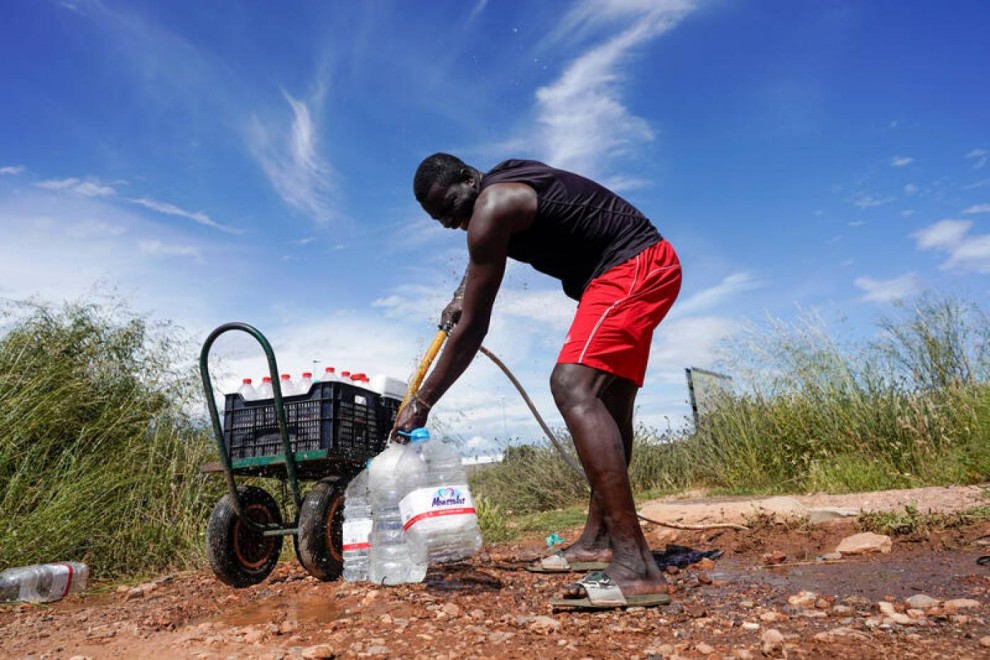 Un trabajador senegalés llena botellas de agua en deprimido del Nazareno, durante el brote de la covid 19 en Níjar, Almería. REUTERS / Juan Medina