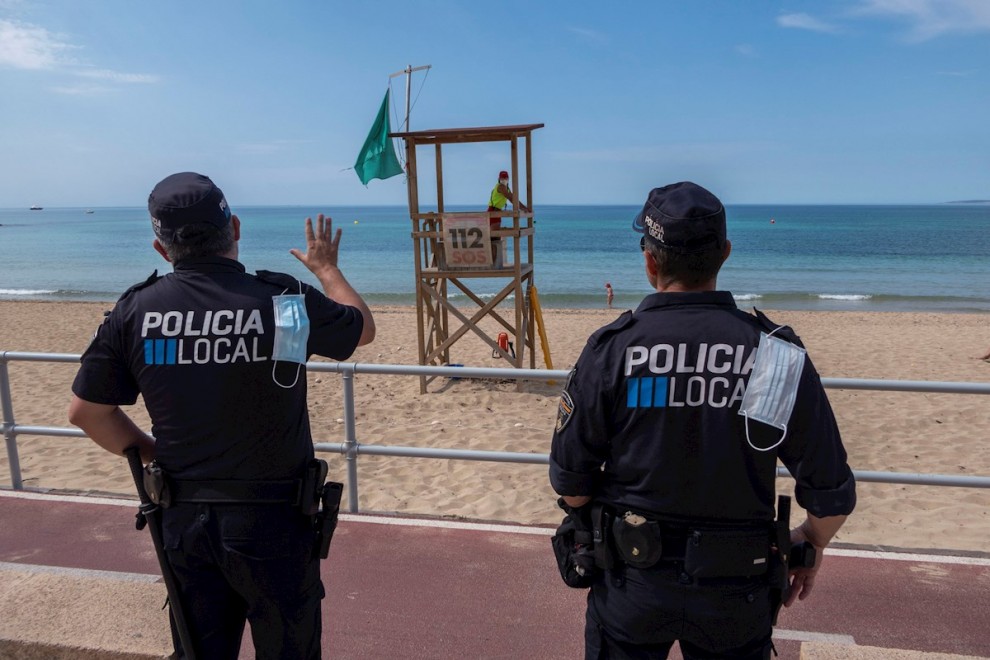 Efectivos policiales vigilan la playa de Can Pere Antoni de Palma. EFE/ CATI CLADERA