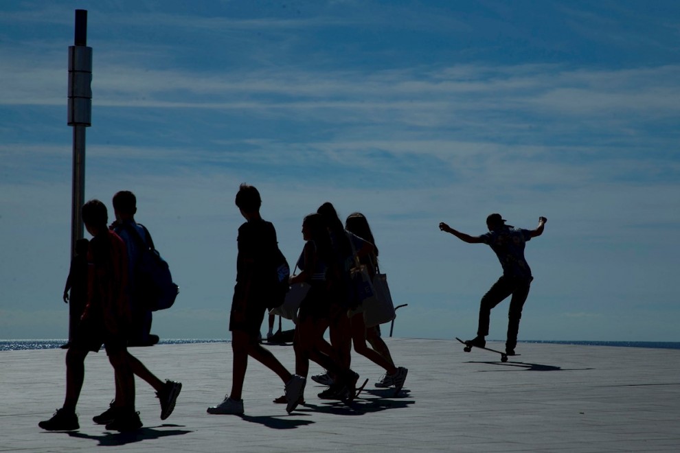 Un grupo de jóvenes caminan por la playa de la Barceloneta. - EFE