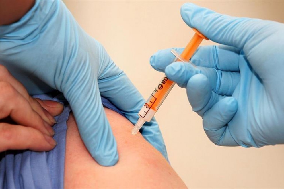 Un trabajador sanitario recibe una dosis de la vacuna contra la gripe A / EFE / Lewis Whyld