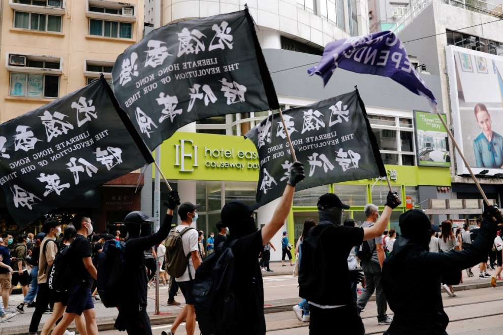 Unos manifestantes sostienen una bandera de independencia de Hong Kong mientras marcha contra la ley de seguridad nacional. REUTERS / Tyrone Siu