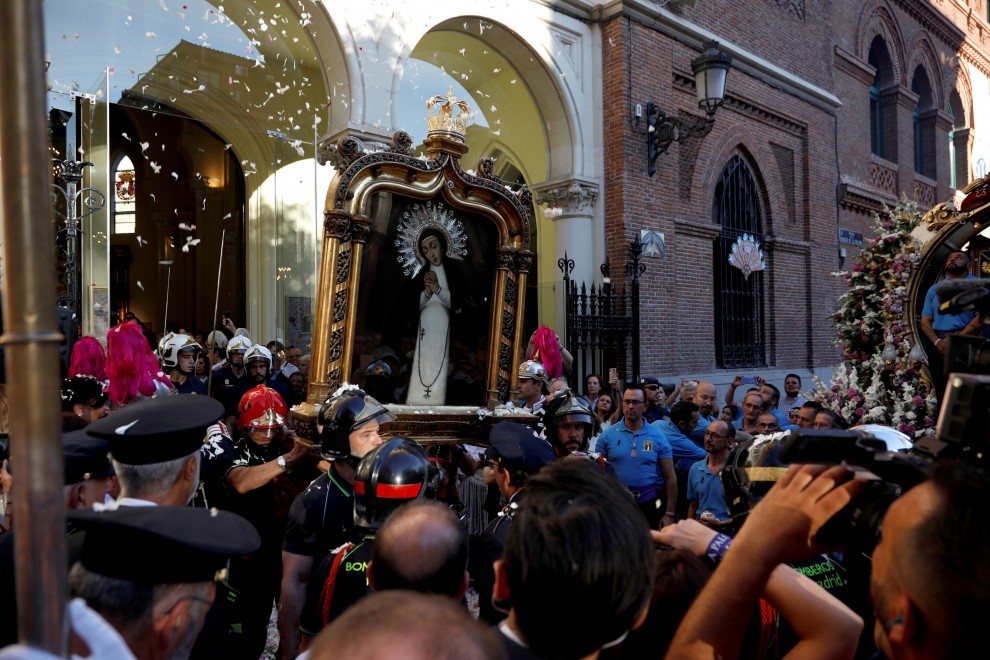 Bomberos sacan al exterior el cuadro de la Virgen de la Paloma, durante la tradicional procesión de la Virgen de la Paloma que tiene lugar en el centro de Madrid. EFE/ David Fernández