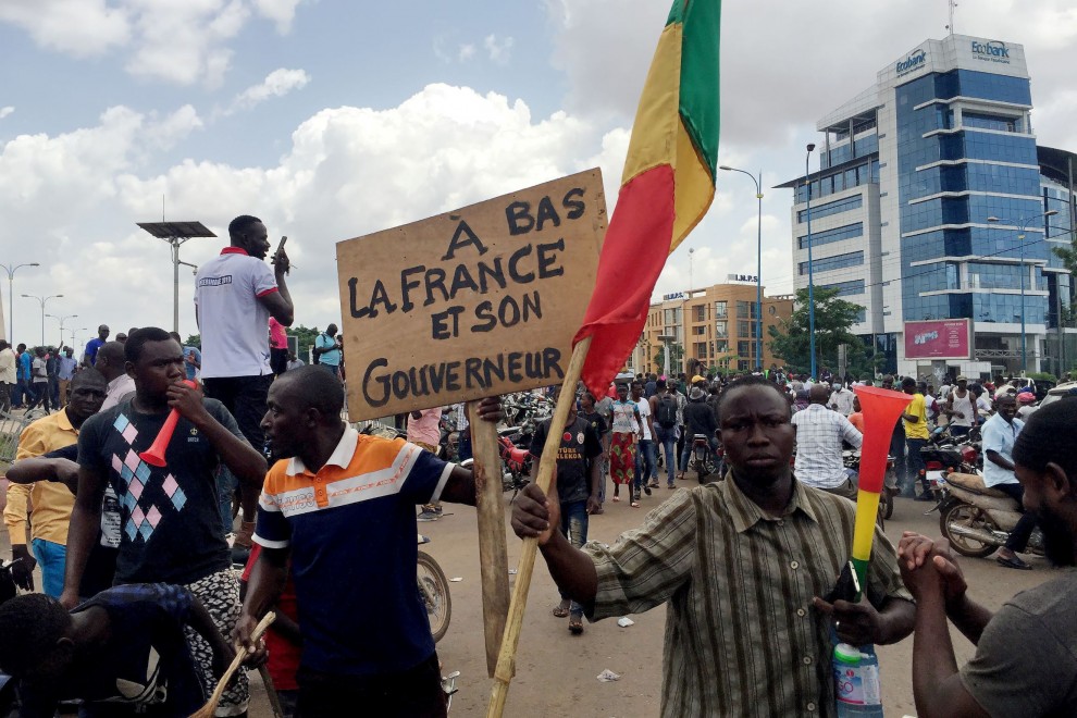 Opositores celebran las noticias sobre un supuesto golpe militar en la plaza de la Independencia de Bamako. El cartel dice:: Fin de Francia y su gobernante.' REUTERS/Rey Byhre