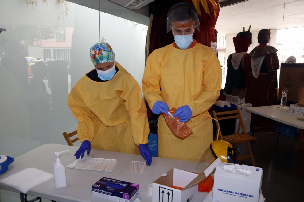 Dos sanitaris preparen un cribatge massiu de PCR. ACN