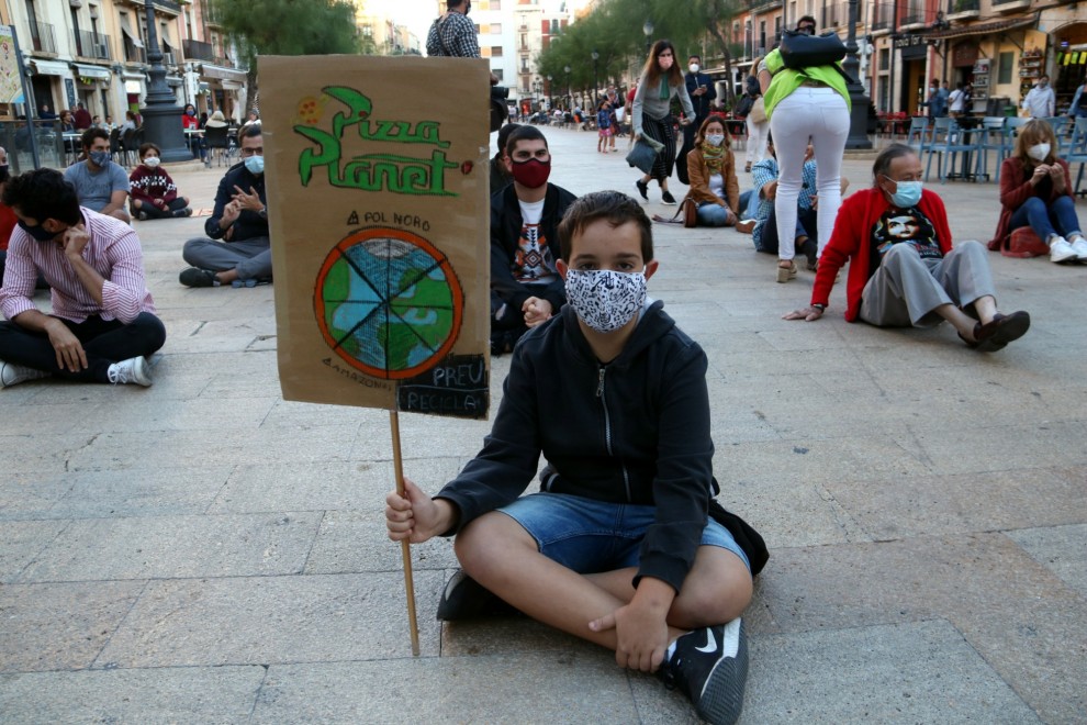 Manifestant amb una pancarta reivindicativa en la protesta organitzada a Tarragona per denunciar l'emergència climàtica. ACN/Mar Rovira