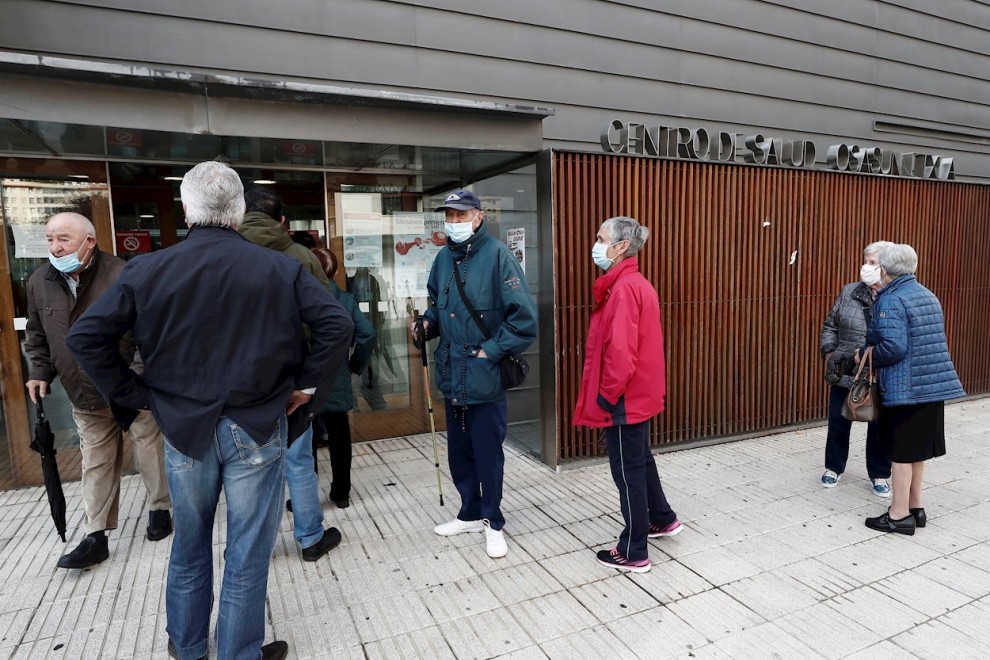 Un grupo de personas esperan en el exterior de un centro de salud de Pamplona para ponerse la vacuna contra la gripe en el primer día de campaña en la comunidad foral. - EFE