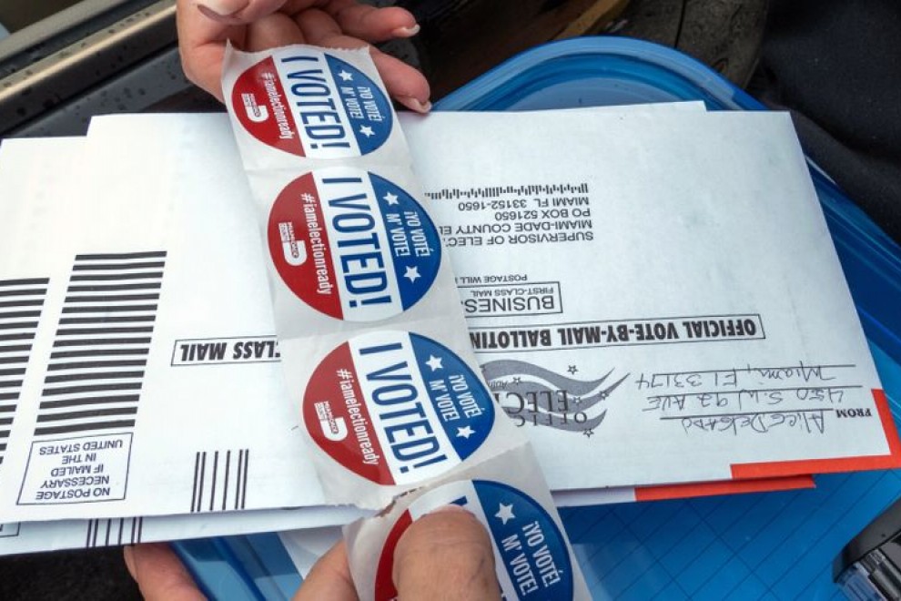 Una persona distribuye unas pegatinas que dicen 'Yo voté', que se entregan a las personas tras votar en la puerta de un centro de votación en Miami, Florida (EEUU). EFE/Giorgio Viera/Archivo