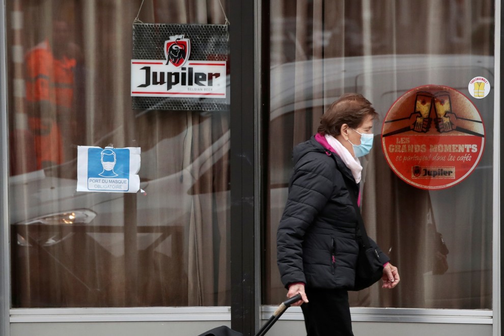 Una mujer pasa frente a un bar cerrado en Bruselas, bélgica–REUTERS
