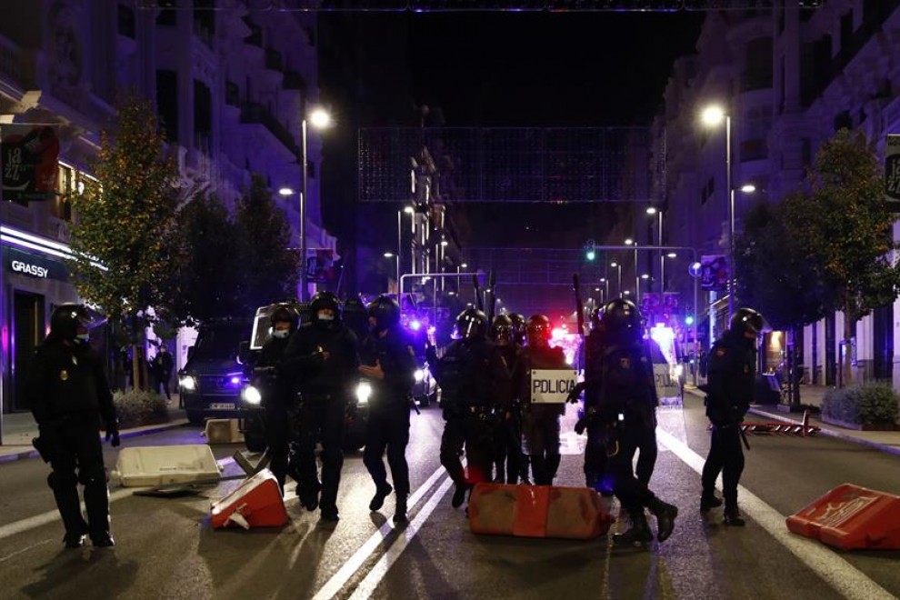 Miembros de la Policía Nacional recorren la Gran Via de Madrid ante las protestas convocadas esta noche por las medidas tomadas tras el aumento de contagios por coronavirus.