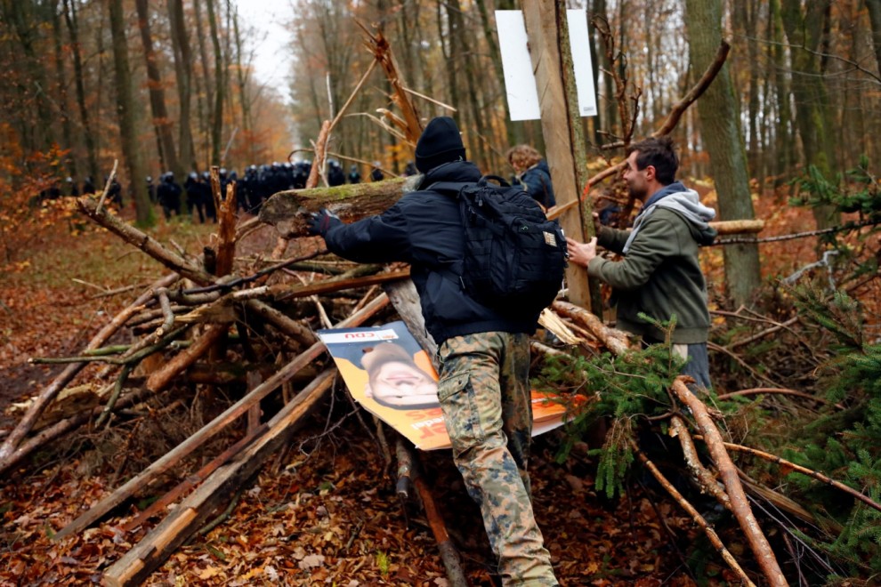 Los manifestantes levantan una barricada de madera después de que los oficiales de policía la desmantelaron durante una protesta contra la extensión de la autopista A49, en un bosque cerca de Stadtallendorf, Alemania.