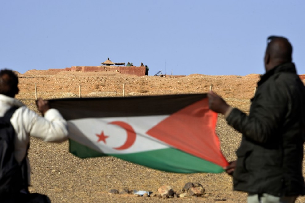 Fotografía de archivo de dos hombres sujetando la bandera del Frente Polisario en el Sáhara.