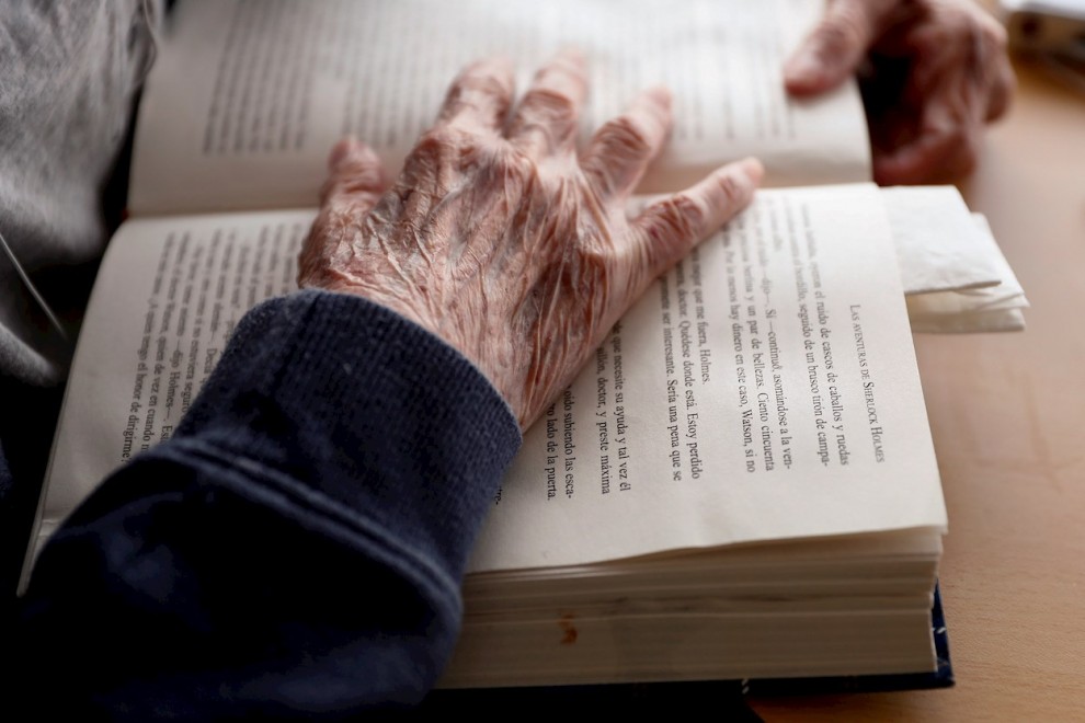 Imagen de archivo de un anciano mientras lee un libro de una residencia.