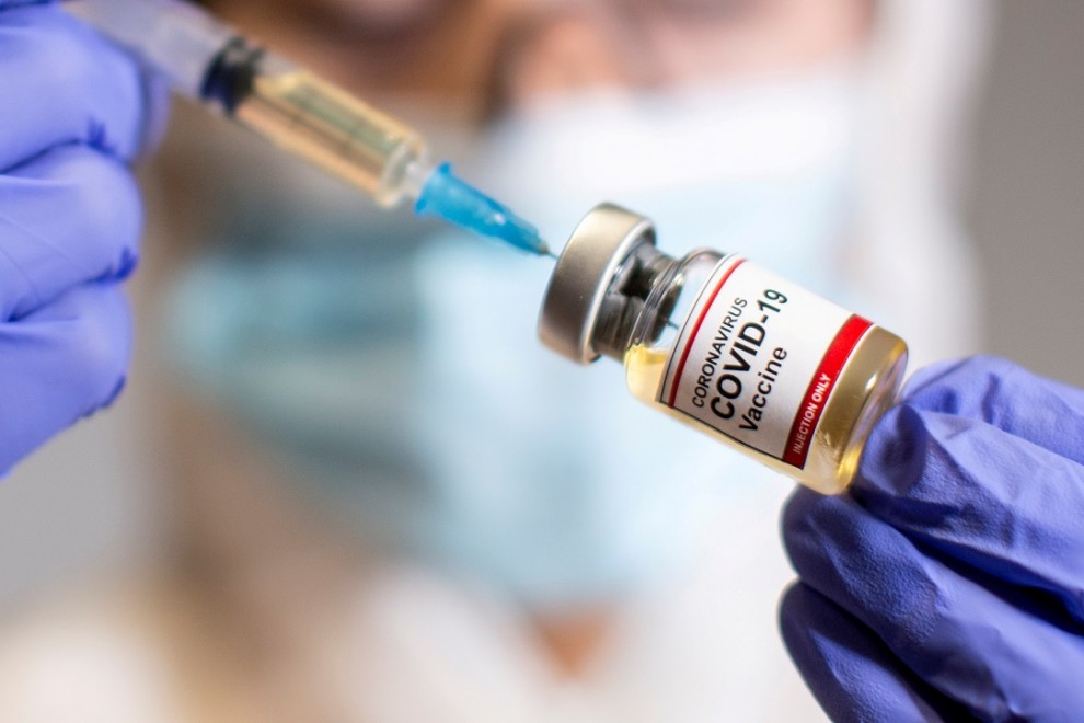 Una sanitaria sostiene una muestra donde se lee 'Vacuna covid-19'