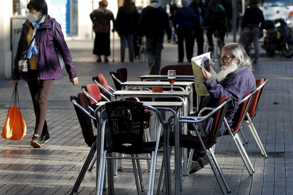 23/11/2020  - Un hombre lee un periódico en la terraza de un bar de Barcelona.