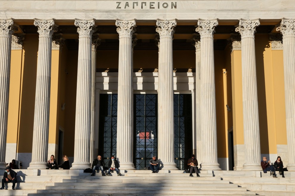 Imagen de varias personas sentadas en las escaleras del edificio Zappeion en Atenas, Grecia