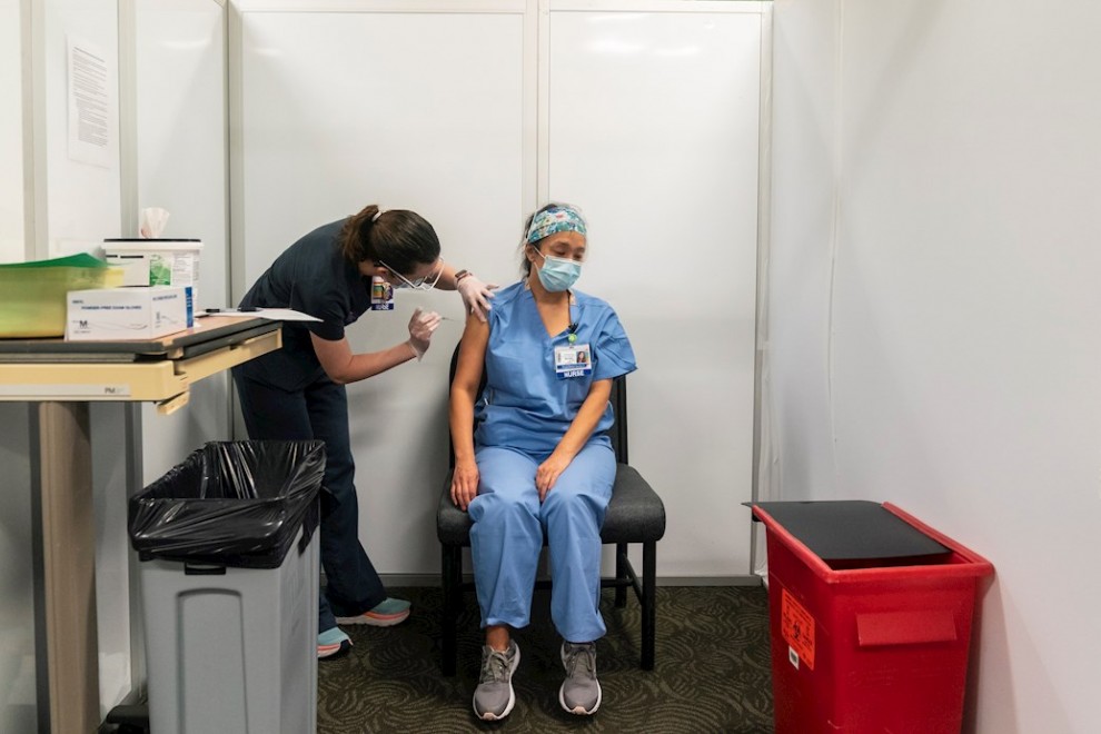Una enfermera de la Universidad de Washignton administra la vacuna de Pfizer-BioTech a una compañera en un centro médico de la Universidad de Washington en Seattle.