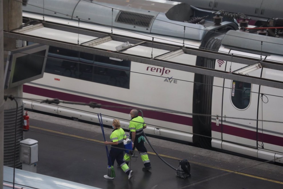 Dos trabajadores pasan junto a un tren AVE de Renfe en un andén en la estación de Atocha, en Madrid. E.P./Marta Fernández Jara