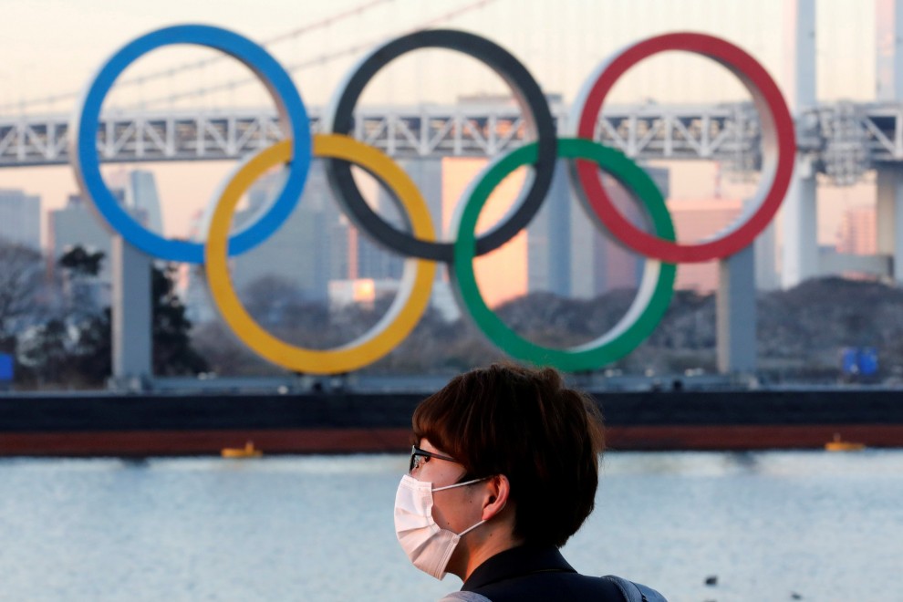 Un hombre frente a una estructura del logotipo de los Juegos Olímpicos en Tokio, Japón