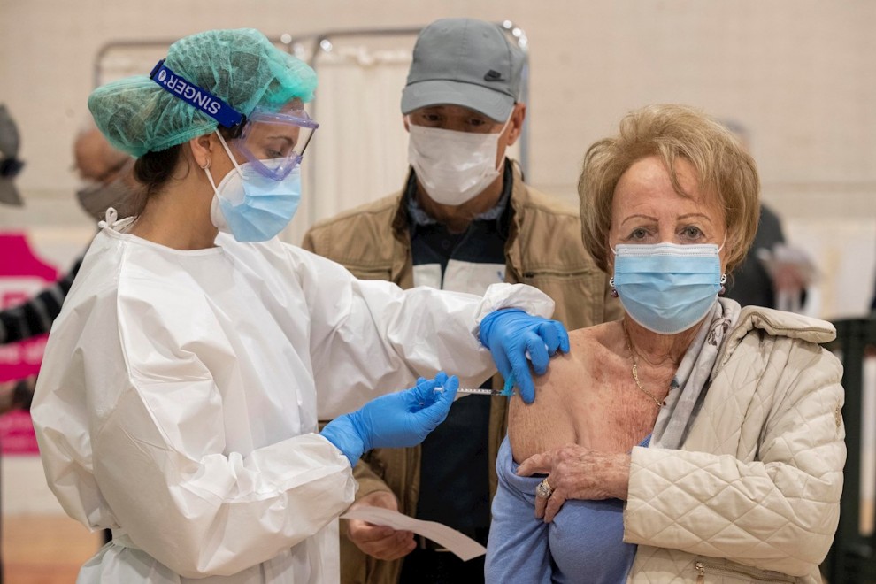 Una sanitaria de la Consejería de salud de la Comunidad de Murcia administra la vacuna Moderna contra la covid-19 a una mujer mayor de 80 años.
