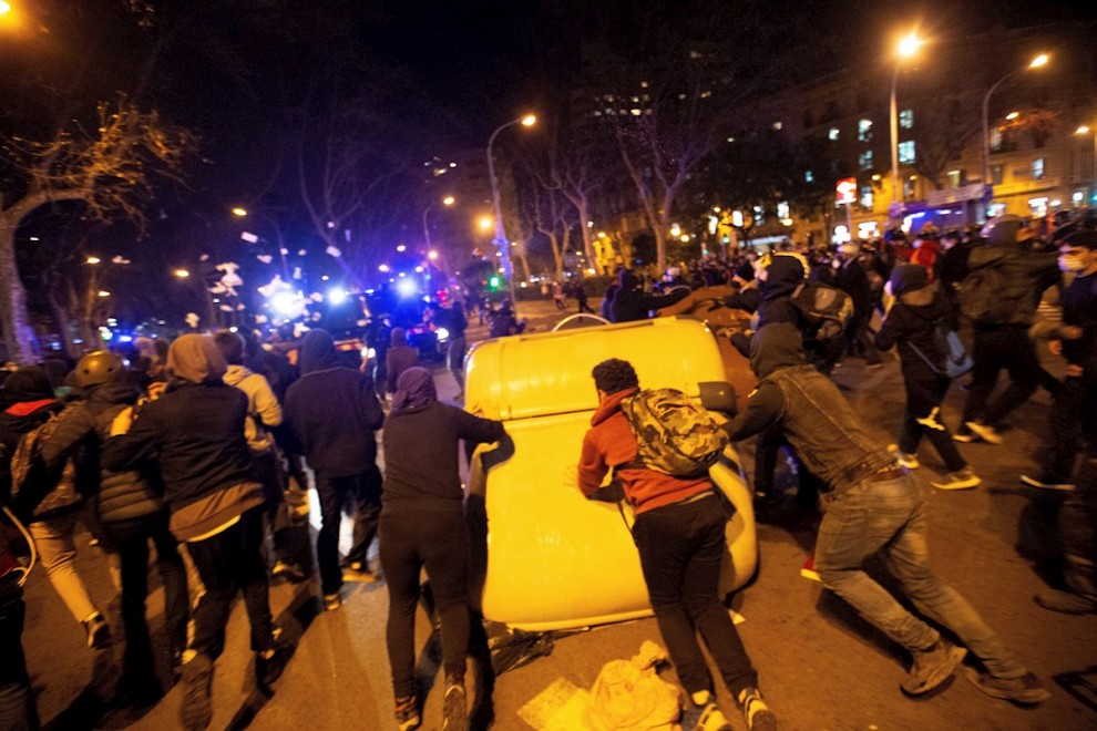 Manifestantes empujan contenedores en la manifestación de protesta por la detención del rapero Pablo Hasél.
