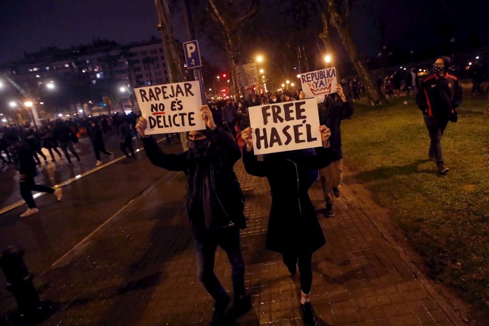 Manifestantes portan pancartas durante una nueva manifestación por la libertad de Pablo Hasel, después de seis días consecutivos de protestas que han finalizado con enfrentamientos con los Mossos d'Esquadra y daños a bienes públicos y privados, este lunes