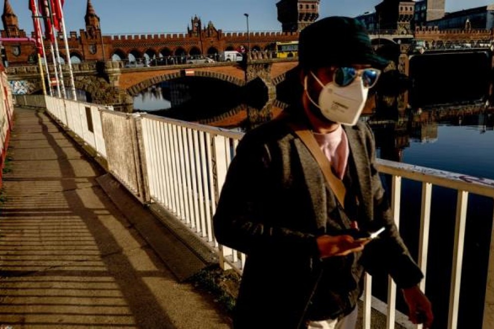 Un hombre usa máscara mientras camina junto al puente Oberbaum en Berlín, Alemania, 02 de marzo de 2021.