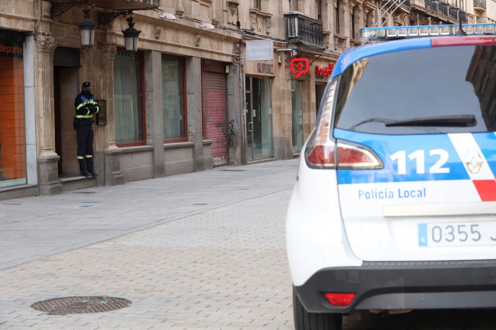 Un agente de la Policía Local de Salamanca vigila a las puertas de un local durante las labores de investigación de una 'fiesta clandestina'.