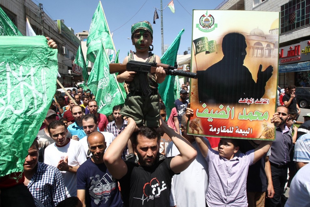 Foto de archivo de agosto de 2014, de una manifestación en Hebrón (Cisjordania) contra Israel, en la que un manifestante sostiene un supuesto retrato del jefe militar de Hamas, Mohammed Deif (derecha). AFP/Hazem Baderhazem