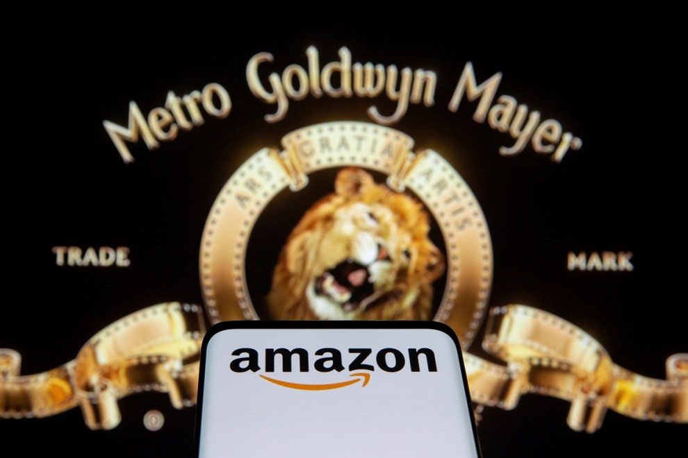 Un smartphone con el logo de Amazon en su pantalla junto al emplema de los estudios MGM. REUTERS/Dado Ruvic/Illustration