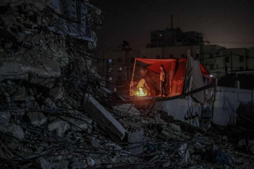 Palestinos sentados dentro de sus tiendas en las ruinas de la ciudad destruida de Beit Hanoun