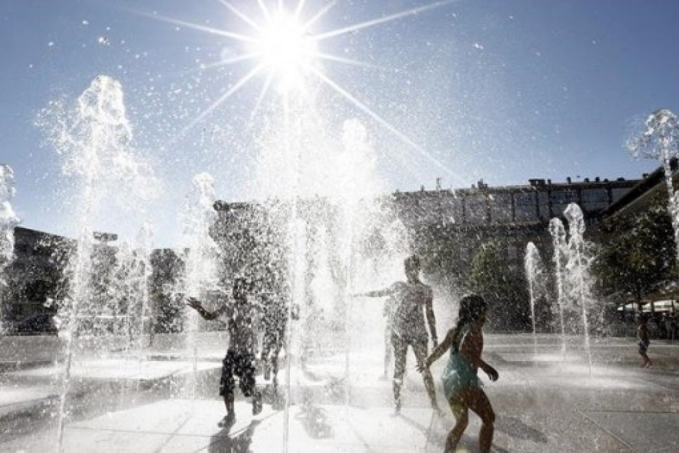 Niños jugando en una fuente pública de Madrid