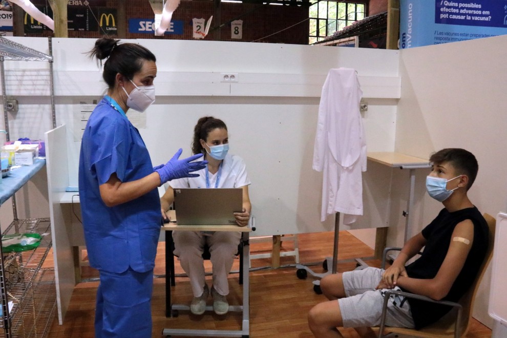 Dues sanitàries amb un jove que ha rebut la vacuna a Lleida.