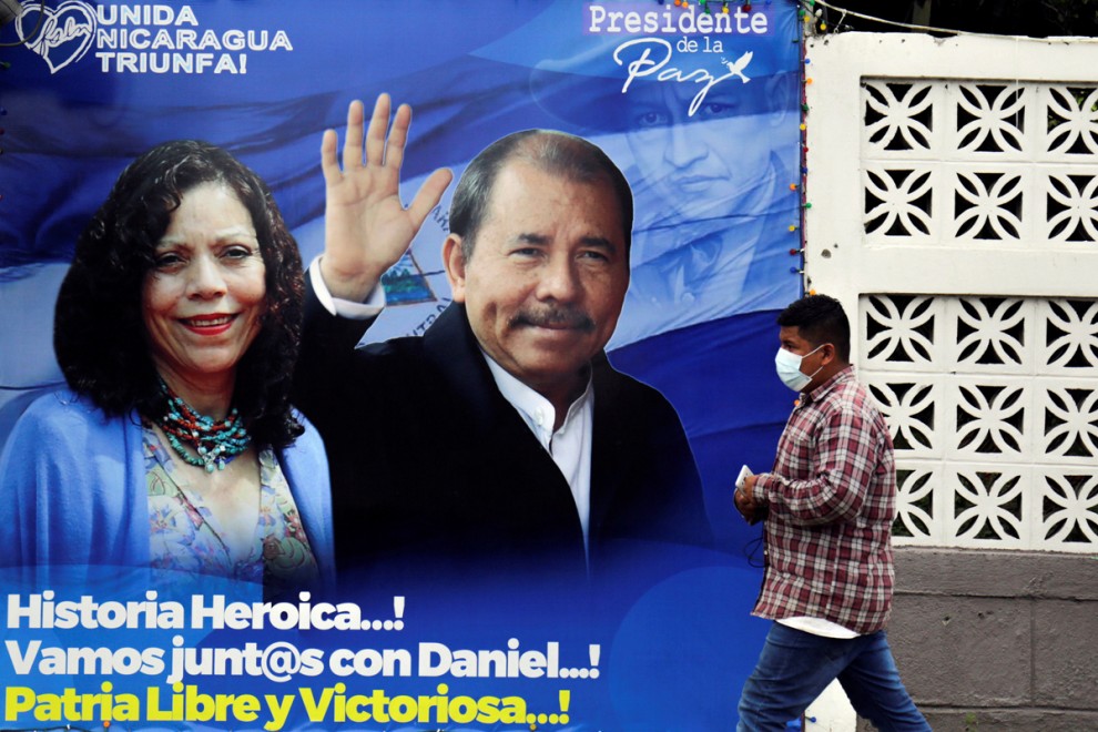 Un hombre pasa junto a un cartel electoral de Daniel Ortega y Rosario Murillo en Managua.