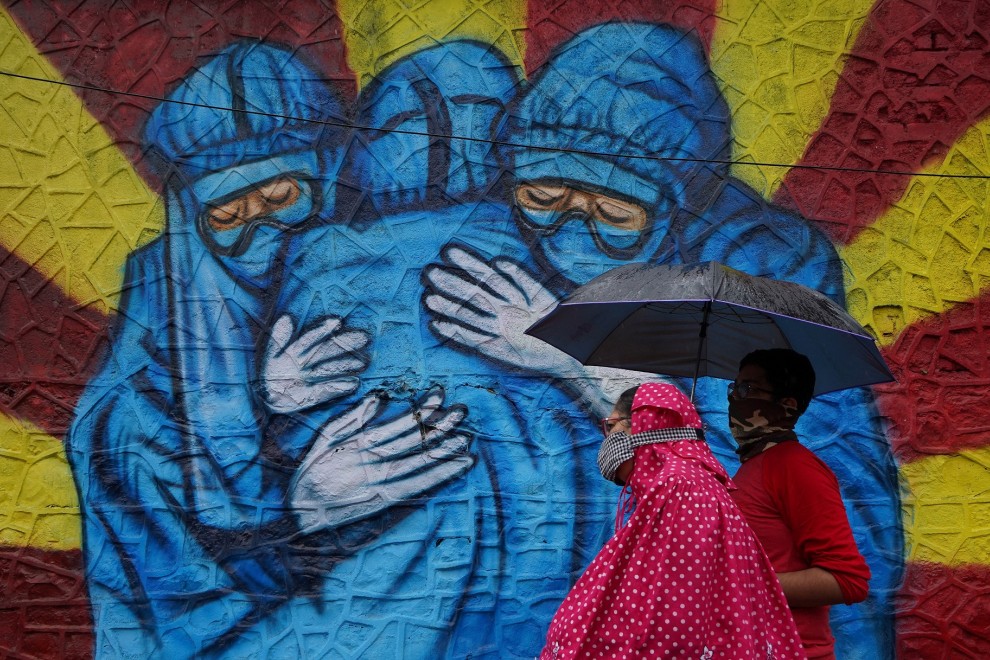 Una mujer y su hijo pasan frente a un graffiti en Mumbai, India.