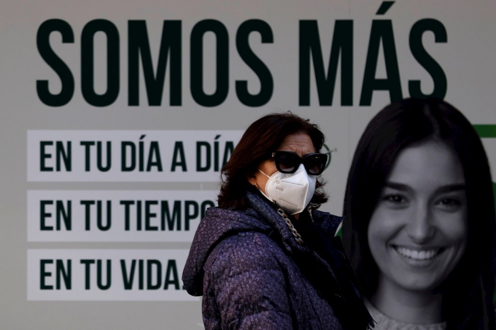 Una mujer camina este jueves con mascarilla por una céntrica calle de La Coruña.