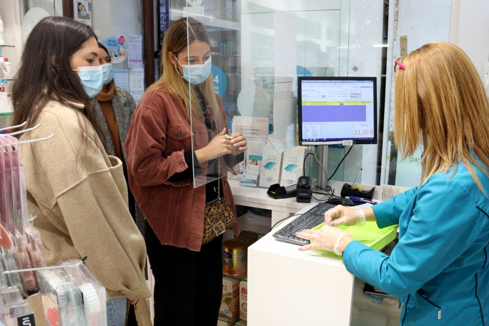 Diverses noies esperant el torn per fer-se un test d'antígens en una farmàcia.