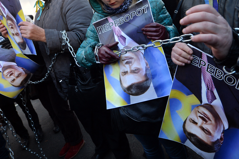 os manifestantes sostienen imágenes rotadas del presidente ucraniano Viktor Yanukovych y firmaron 'Al revés' (en ucraniano la palabra también tiene otro significado: derrocamiento y revolución) durante la acción de protesta en el Ministerio del Interior e