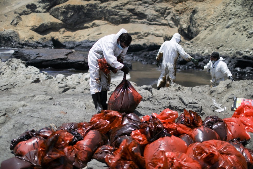 Voluntarios y pescadores recogen petróleo de la costa de Ventanilla.