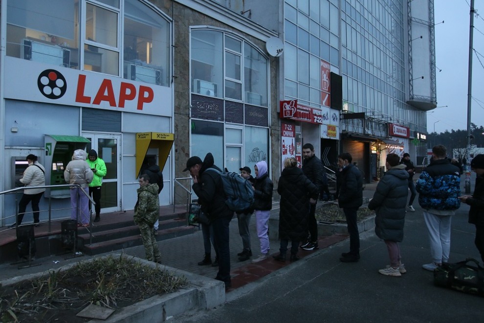 La gente hace cola en un cajero automático (ATM) en una sucursal de un banco en Kiev, el 24 de febrero de 2022, en Kiev, Ucrania