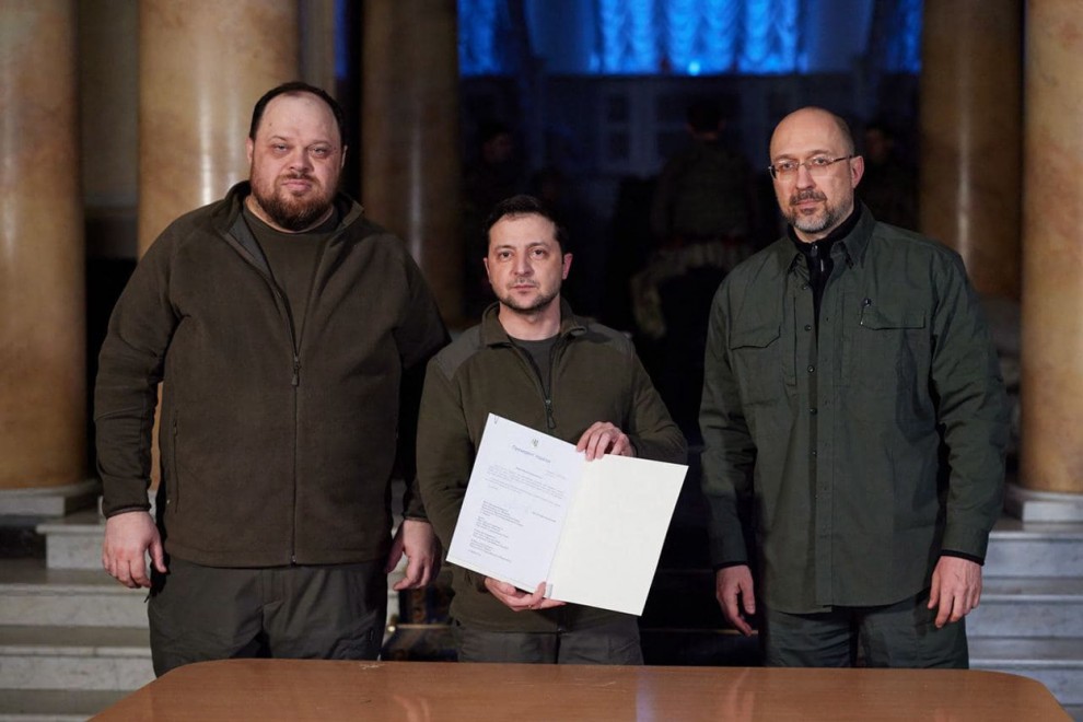 El presidente ucraniano, Volódimir Zelenski, entre el primer ministro Denys Shmyhal, y el presidente del parlamento, Ruslan Stefanchuk, firma la solicitud de ingreso en la Unión Europea.