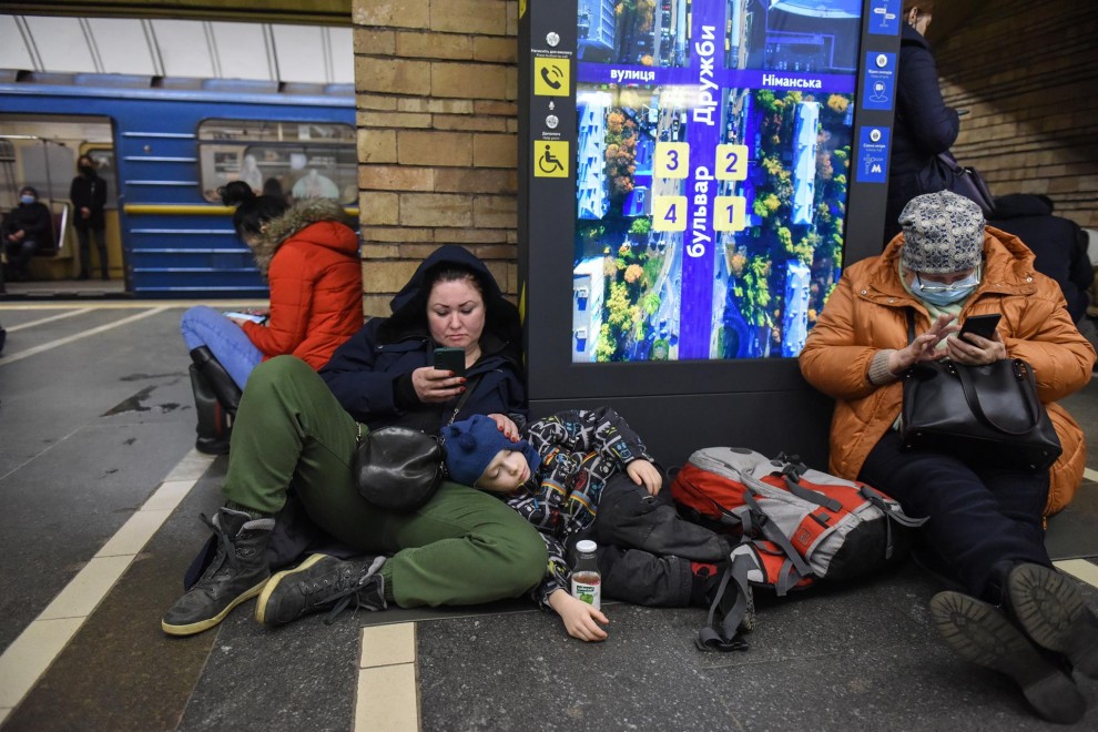 Dos mujeres, junto a un niño recostado, se refugian en el metro de Kiev el pasado 24 de febrero tras al ataque masivo de Rusia a Ucrania.